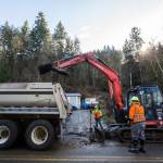Snohomish County Public Works cleans up leftover mud from the slide Monday in Monroe. (Olivia Vanni / The Herald)
