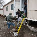 In this Feb. 8 photo, resident Patty Haid is helped from her flood-damaged home in Pendleton, Oregon. (Ben Lonergan/East Oregonian via AP)