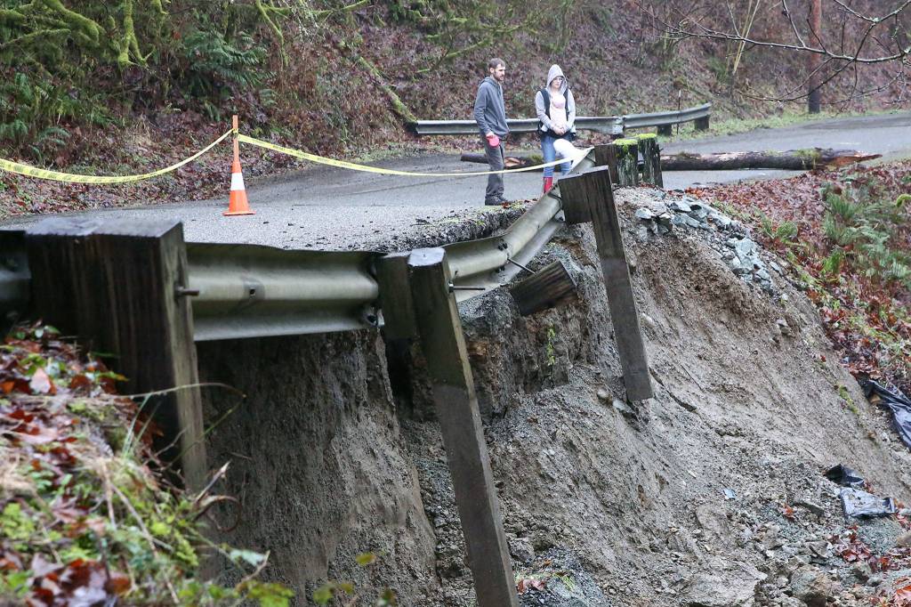 Concerned down slope residents look over mudslide on 260th Ave NE leading to Skyview Estate in Monroe on February 13, 2020. (Kevin Clark / The Herald)