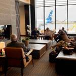 People wait for their flights in the fireplace lounge at Paine Field airport Thursday morning. (Sue Misao / The Herald)