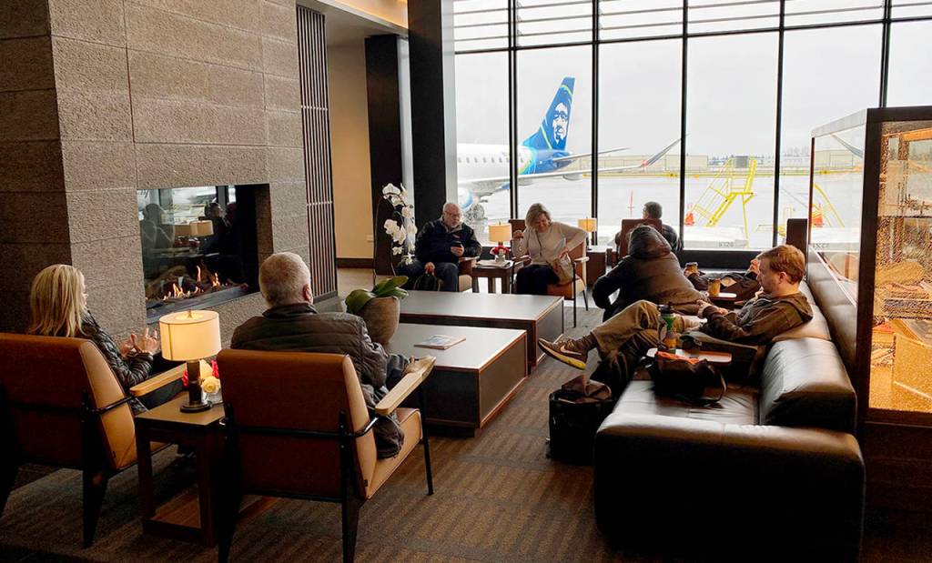 People wait for their flights in the fireplace lounge at Paine Field airport Thursday morning. (Sue Misao / The Herald)