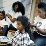 Sisters Shelly Smith (back) and Glynnis Smith (right) braid hair for Bridget Dunmore (left) and Alicia McGee (front) at their salon, Braid Heaven, on Jan. 28 in Kansas City, Kansas. Legislators in Kansas and Wisconsin are considering whether to revise their states anti-discrimination laws to ban bias in housing, employment and public accommodations based on hairstyles historically associated with race such as braids, locs and twists. (AP Photo/Charlie Riedel)