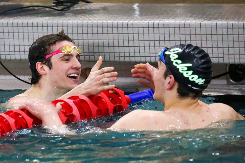 Glacier Peaks Matthew King celebrates with Jensen Elsemore of Jackson at the end of 100-yard freestyle during the 4A NW District Swim Meet on Feb. 15, 2020, at the Snohomish Aquatic Center. (Kevin Clark / The Herald)