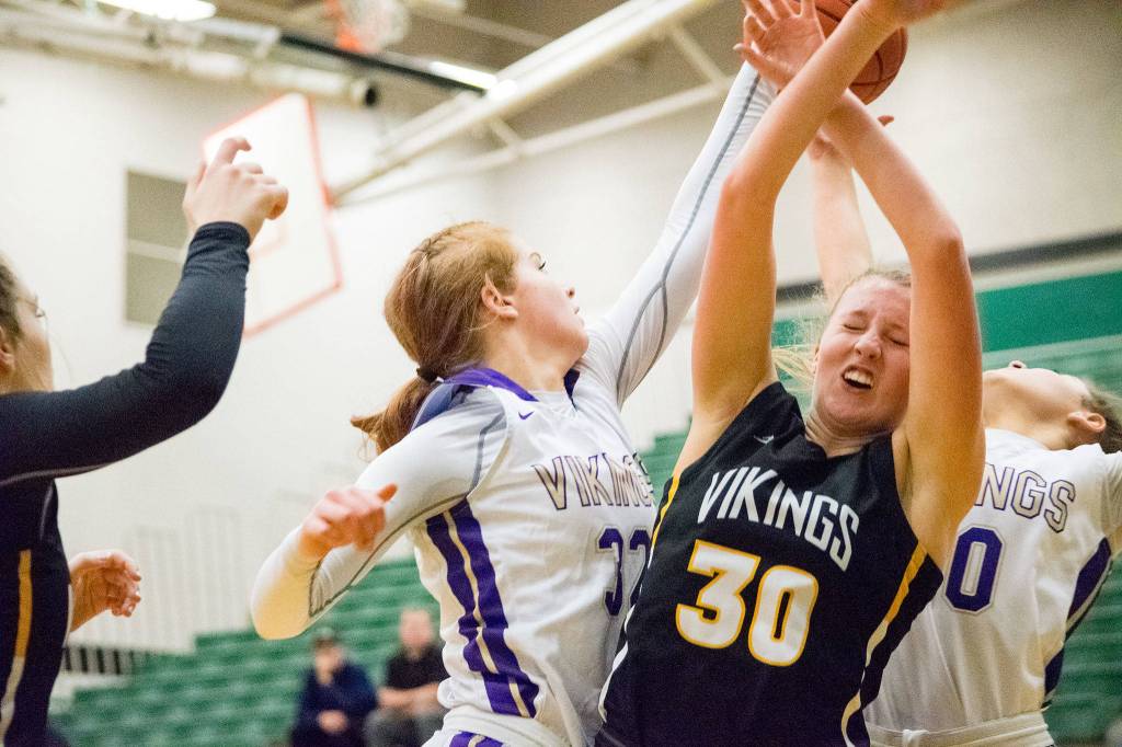 Lake Stevens Cori WIlcox (left) jumps up for a rebound against Inglemoors Abby Haller (30) in a Wes-King Bi-District Tournament winner-to-state, loser-out game on Thursday at Jackson High School in Mill Creek. (Katie Webber / The Herald)