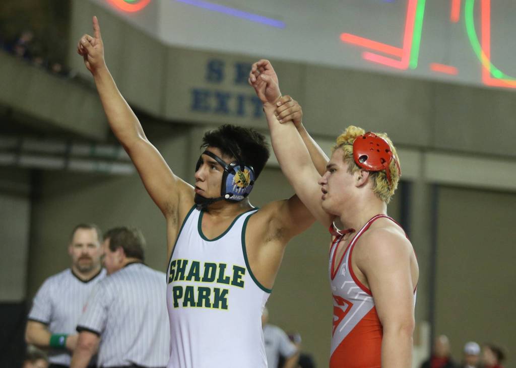 Stanwoods Riley Van Scoy (right) has his arm raised by Shadle Parks Juan Escobar after losing in the 3A 170-pound championship match during Mat Classic XXXII on Saturday at the Tacoma Dome. (Andy Bronson / The Herald)