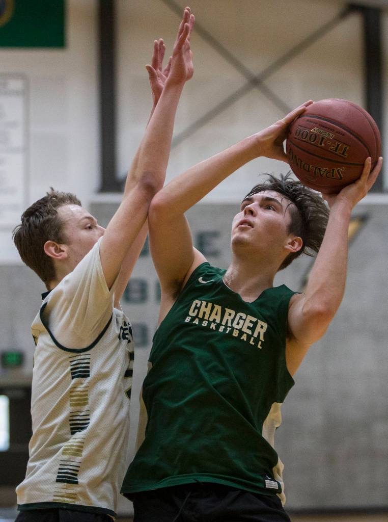 Will Dunn, right, attempts a layup as Ryan Allison, left, blocks during practice on Wednesday, Feb. 26, 2020 in Marysville, Wash. (Olivia Vanni / The Herald)