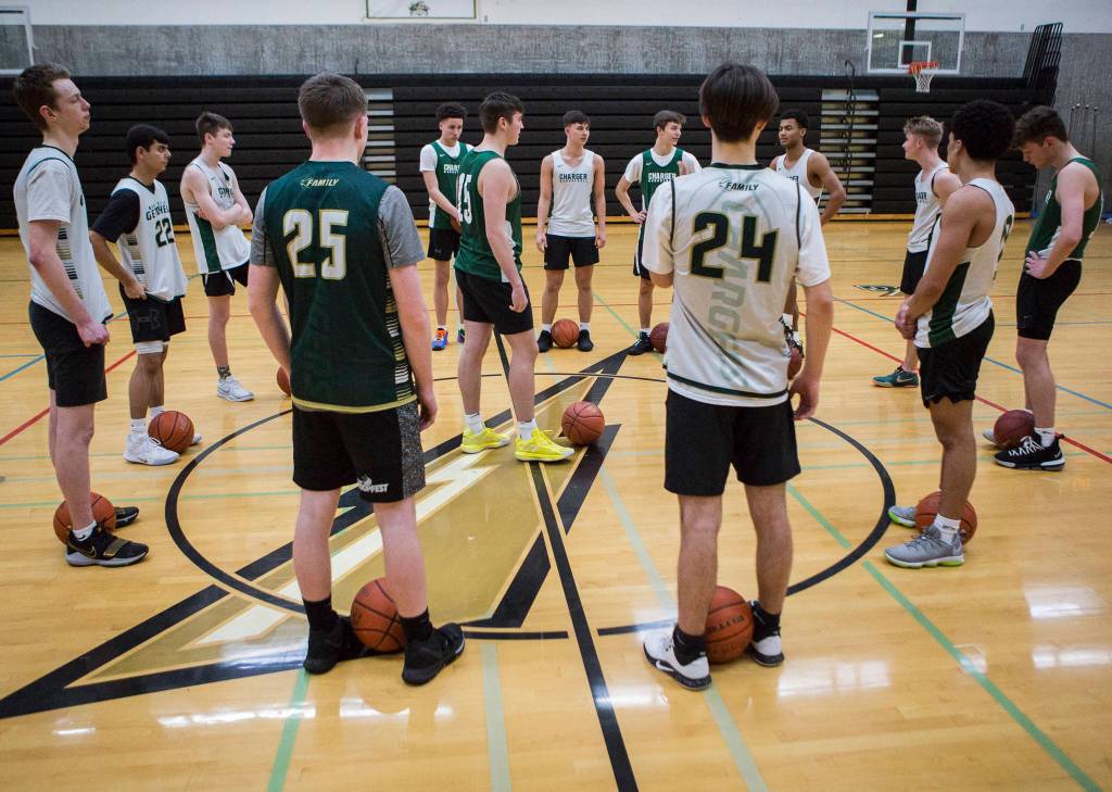 The team gathers at the center of the court before the start of practice on Wednesday, Feb. 26, 2020 in Marysville, Wash. (Olivia Vanni / The Herald)