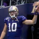 Washington quarterback Jacob Eason, a Lake Stevens alum, high-fives fans as he walks out onto the field before a game against Oregon on Oct. 19, 2019, in Seattle. (Olivia Vanni / The Herald)