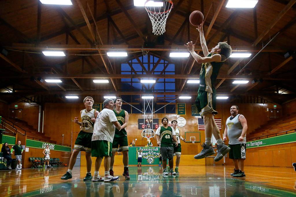 Darrington senior guard Brevin Ross (second from right) goes up for a layup during practice Tuesday evening at Darrington High School. (Kevin Clark / The Herald)
