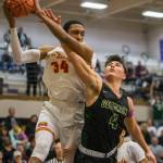 Marysville Getchells Landyn Olson (4) battles Mount Tahomas Lezjaun Harris for a rebound during a 3A state regional game on Friday in Puyallup. (Olivia Vanni / The Herald)