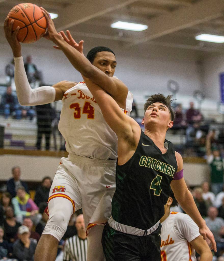 Marysville Getchells Landyn Olson (4) battles Mount Tahomas Lezjaun Harris for a rebound during a 3A state regional game on Friday in Puyallup. (Olivia Vanni / The Herald)
