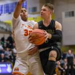 Marysville Getchells Josiah Koellmer drives to the hoop past Mount Tahomas Leo Ruiz during a 3A state regional game on Friday in Puyallup. (Olivia Vanni / The Herald)