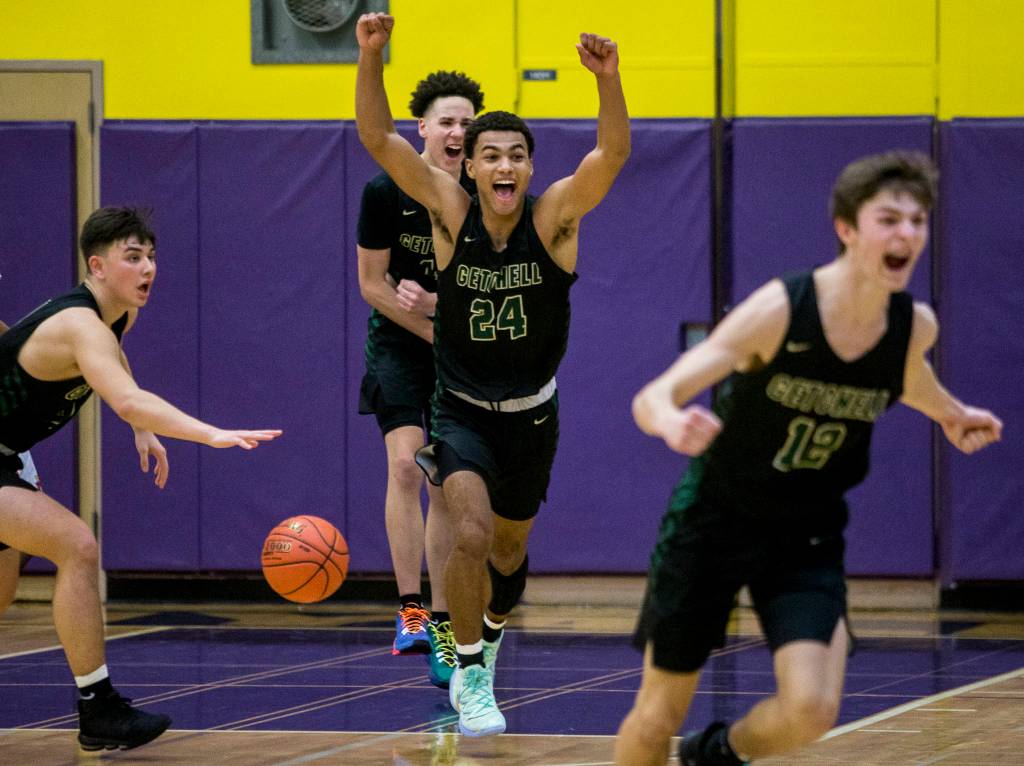 Marysville Getchells Malakhi Knight (24) raises his arms and runs toward the bench with his teammates after beating Mount Tahoma in a 3A state regional game on Friday in Puyallup. (Olivia Vanni / The Herald)