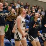 The Arlington bench reacts to a teammate making a 3-point shot during a 3A state regional game against Lake Washington on Saturday in Shoreline. (Olivia Vanni / The Herald)