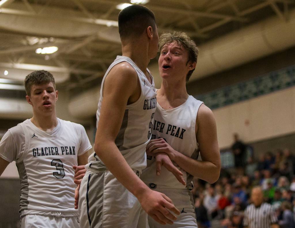 Glacier Peaks Tucker Molina (5) and Tristen Bates (right) celebrate a foul called on Auburn during a 4A state regional game on Saturday at Shorewood High School in Shoreline. (Olivia Vanni / The Herald)