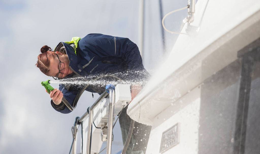 Kelly Jane Heindel cleans a 40-foot yacht at the Everett Marina. (Andy Bronson / The Herald)