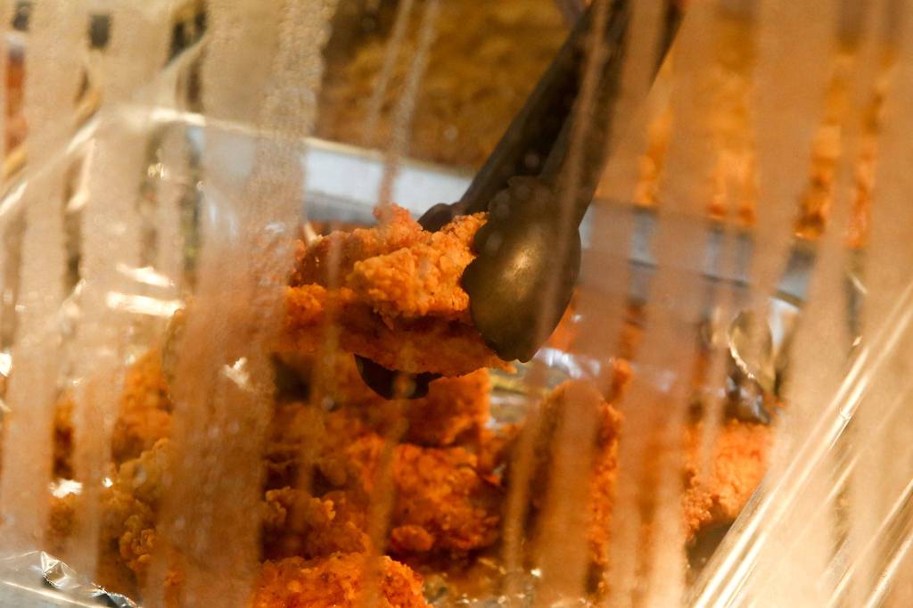 Fried chicken under glass at Grandmas in da Kitchen on West Marine View Drive in Everett. (Kevin Clark / The Herald)