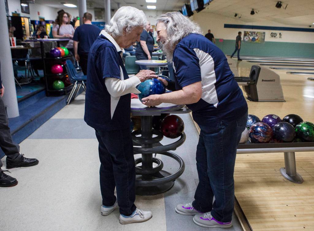 Carol Perry high fives her daughter Kathy Larsen before her turn to bowl during league bowling. (Olivia Vanni / The Herald)