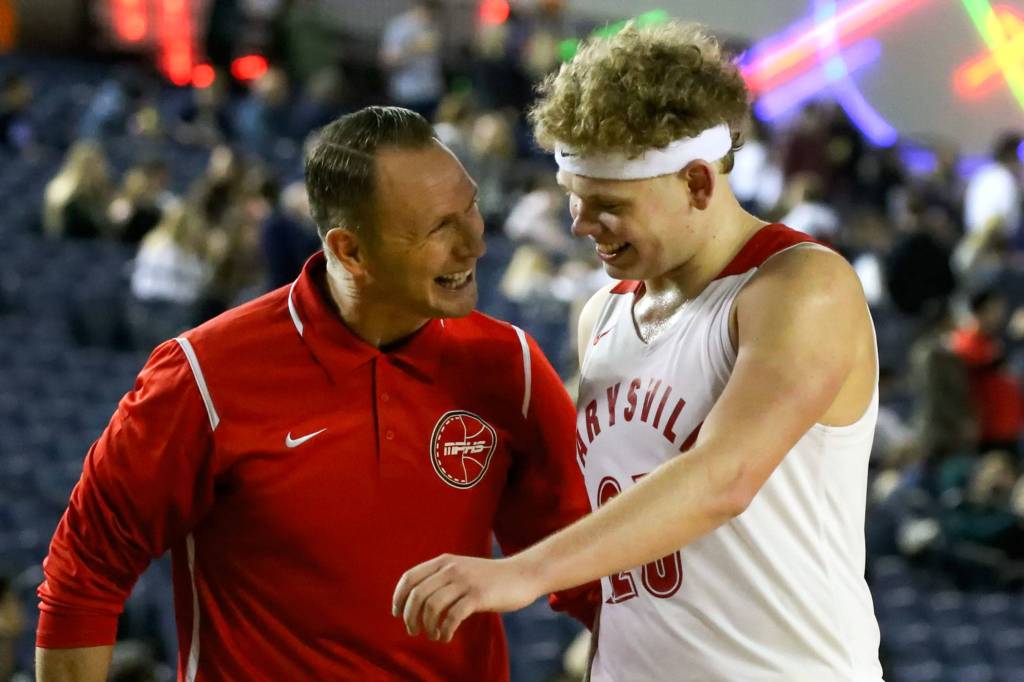 Marysville Pilchuck coach Bary Gould greets Cameron Stordahl after subbing him out of a 3A boys Hardwood Classic game against Central Kitsap Wednesday morning at the Tacoma Dome. (Kevin Clark / The Herald)