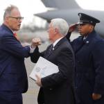 Vice President Mike Pence (center) bumps elbows with Gov. Jay Inslee as Pence arrives, Thursday at Joint Base Lewis-McChord. The men were avoiding a handshake because of the Covid-19 coronavirus. (Ted S. Warren / Associated Press)