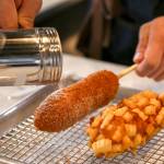 Co-owner Sean Lee sprinkles sugar on corn dogs at Seoul Hotdog in Lynnwood. (Kevin Clark / The Herald)