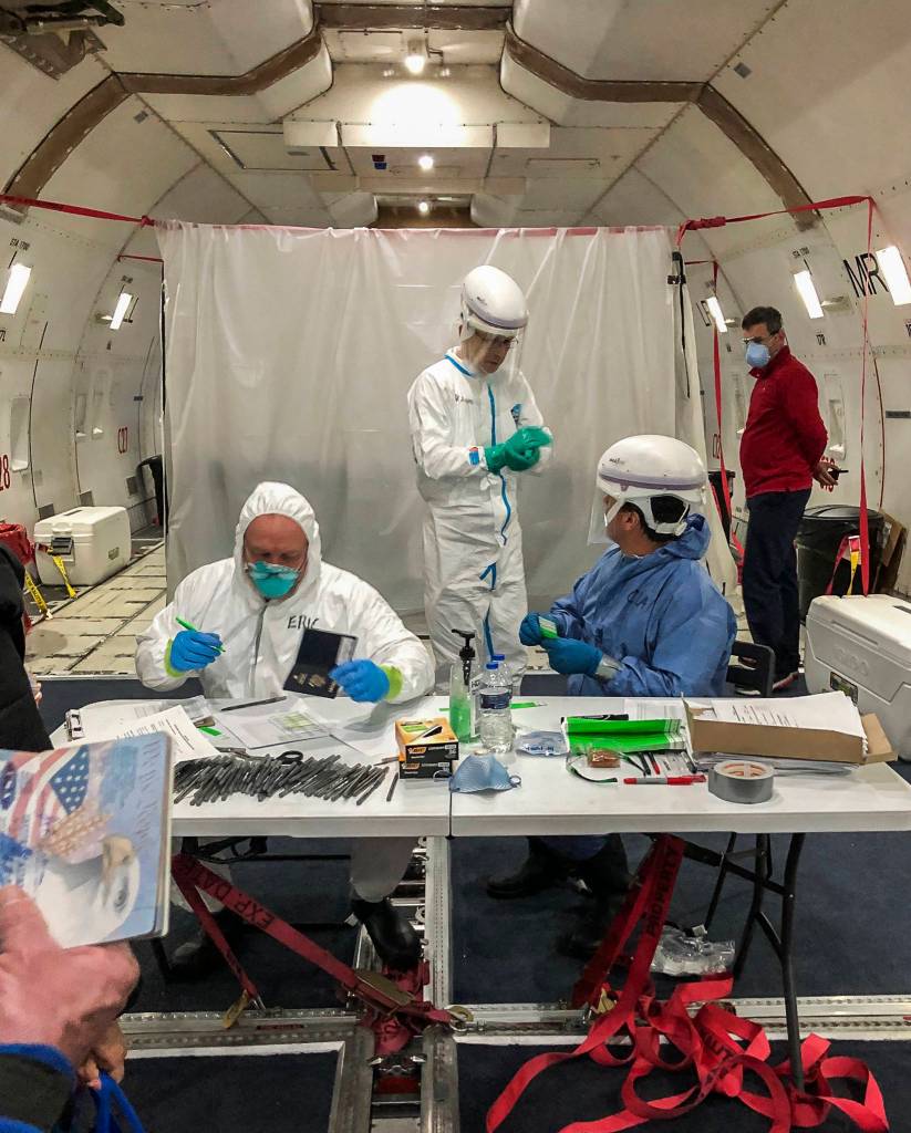 Officials check passengers passports as they board the plane that will take them to Travis Air Force Base on Feb. 17. (Susan Anabel)