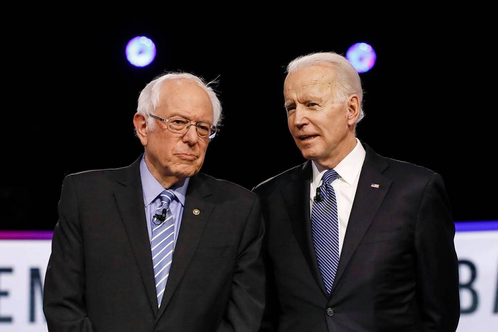 Democratic presidential candidates former Vice President Joe Biden (left) and Sen. Bernie Sanders talk before a Democratic presidential primary debate on Feb. 25 in Charleston, South Carolina. (AP Photo/Matt Rourke)