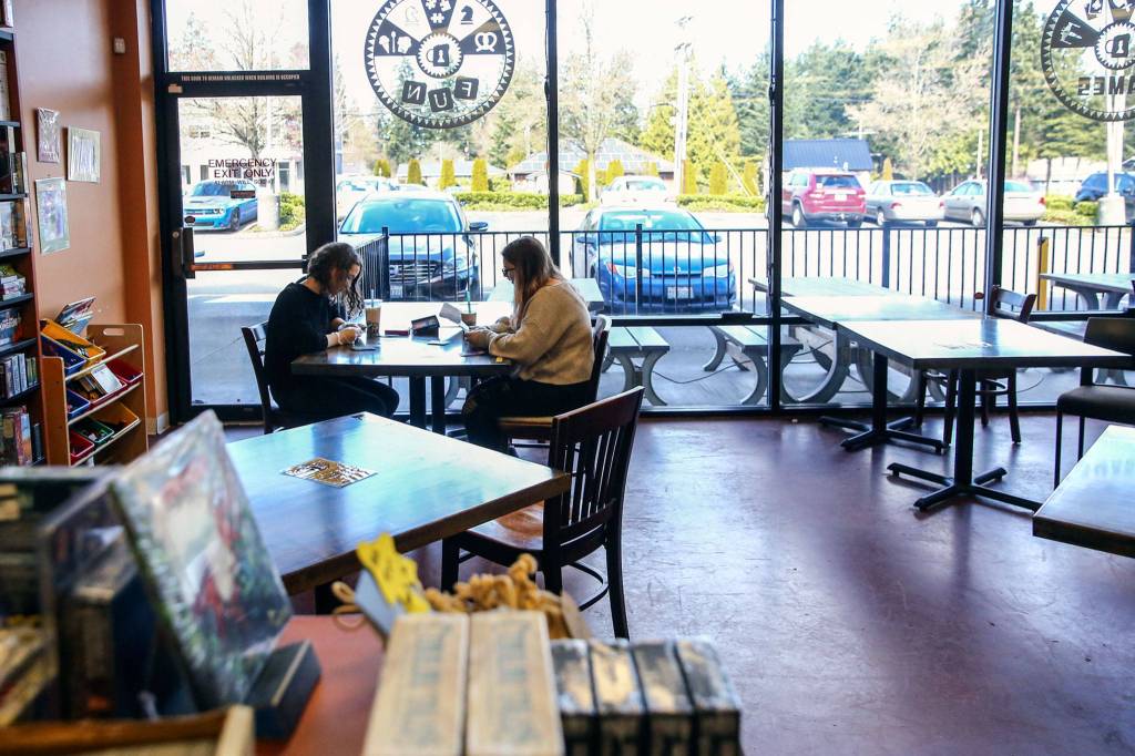 Customers play a game March 15 in the unusually empty setting at Around the Table Game Pub in Lynnwood. (Kevin Clark / The Herald)