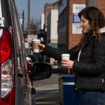 Narrative Coffee employee Eugenia Nestico hands off coffee to customers on Thursday in Everett. (Olivia Vanni / The Herald)