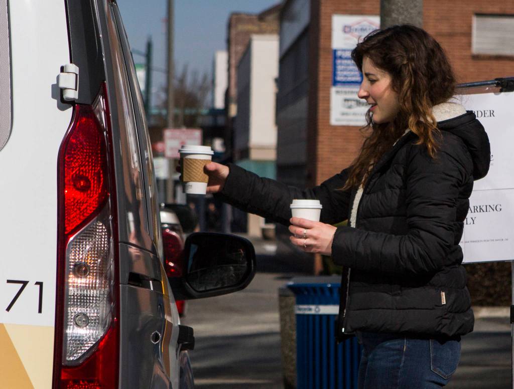 Narrative Coffee employee Eugenia Nestico hands off coffee to customers on Thursday in Everett. (Olivia Vanni / The Herald)