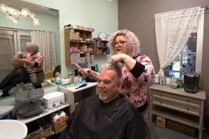 HoneyComb Salon owner Julia Barbee gives Don Zimmerman a haircut in her studio inside Sola Salon Studios on Friday in Mill Creek. On Monday, the state ordered all salons closed for at least two weeks. (Andy Bronson / The Herald)