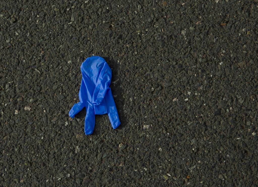 A discarded latex glove lays on the ground outside of Costco on Tuesday in Everett. (Olivia Vanni / The Herald)