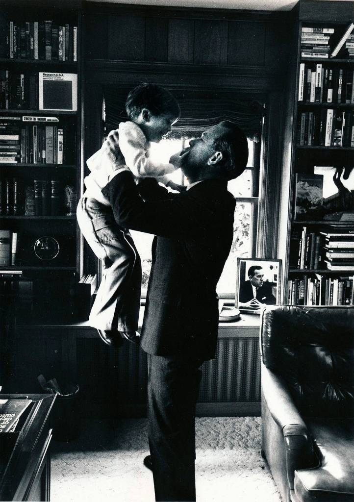 In the familys home library in Everett, Sen. Henry M. Scoop Jackson scoops up his young son Peter in his arms.