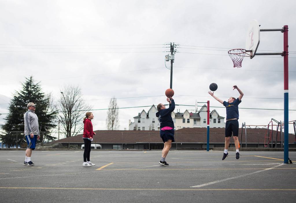 The Cook family plays bump Saturday during their daily P.E class that they do as a family to get out of the house in Everett. (Olivia Vanni / The Herald)