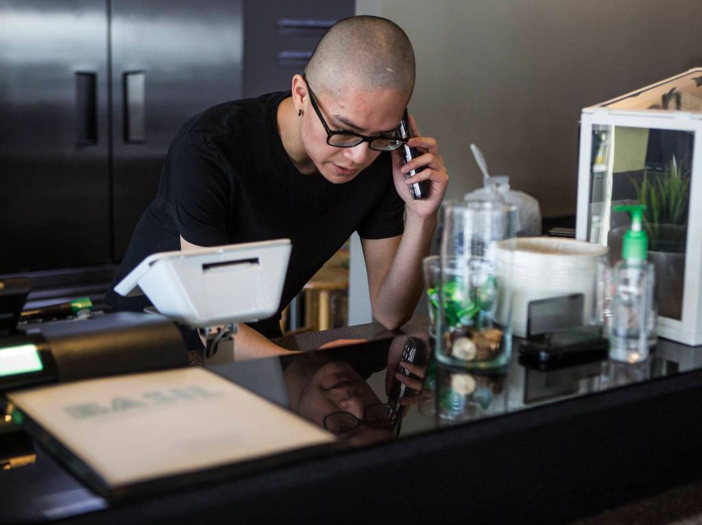 Anthony Luong takes a pick-up order over the phone at Basil Authentic Vietnamese Cuisine on April 5 in Everett. (Olivia Vanni / The Herald)