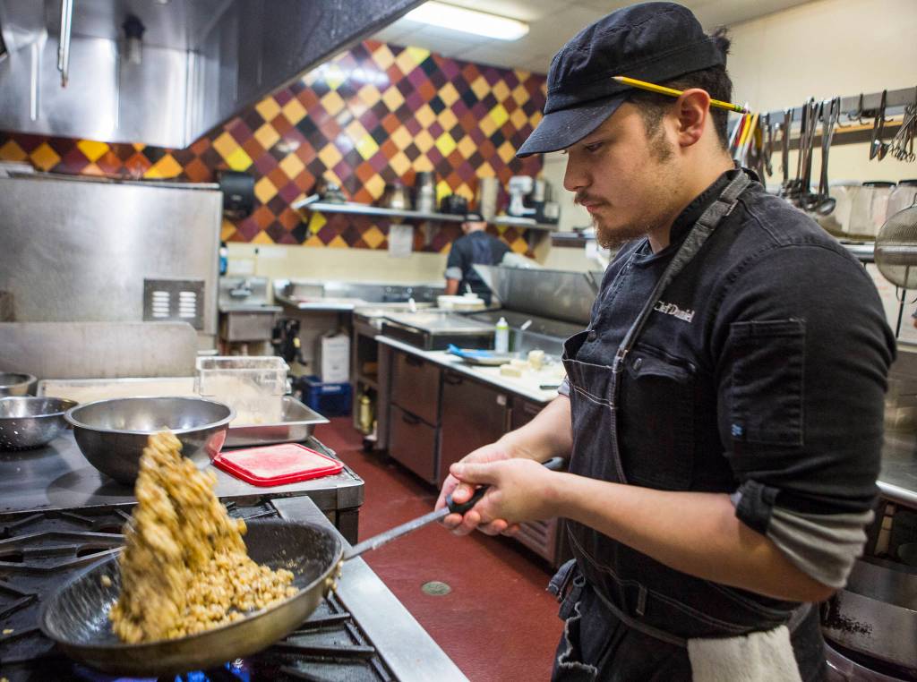 Senior sous-chef Daniel Demidoff preps walnuts in the kitchen on Jan. 30 in Everett. (Olivia Vanni / The Herald)