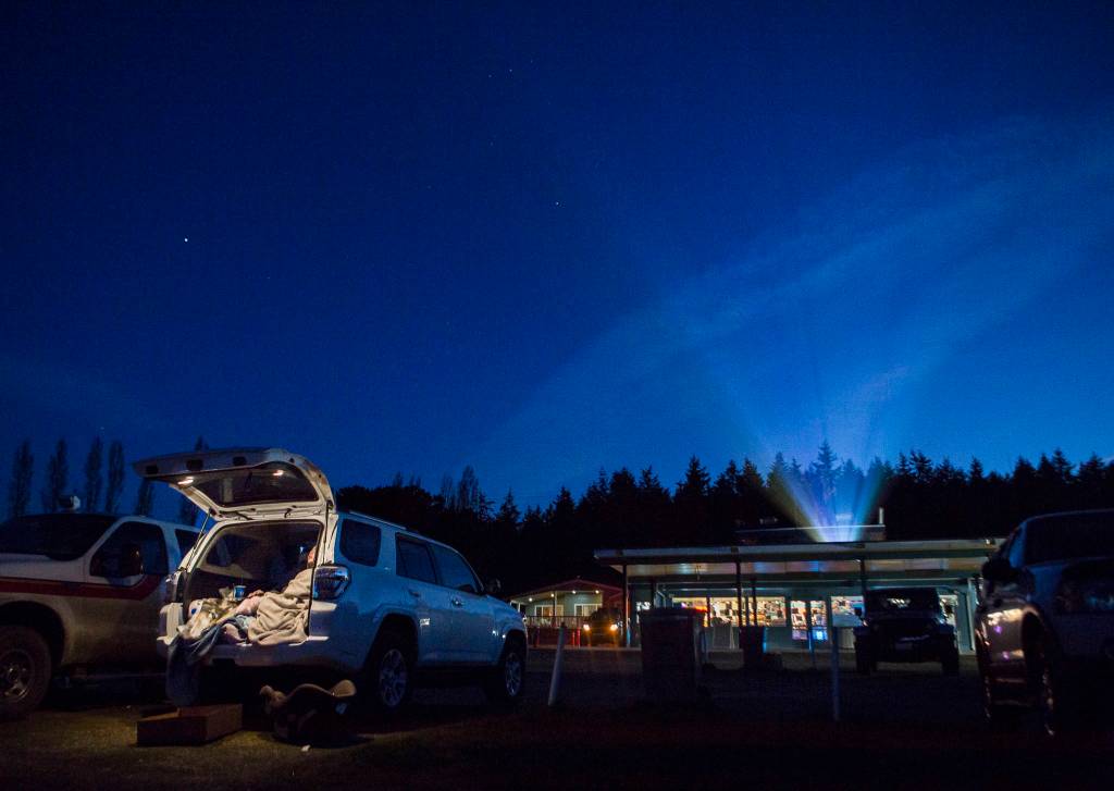 People bundle up in blankets in their cars as the first movie of a double feature, Disneys Onward, begins to play at the Blue Fox Drive-In on March 19 in Oak Harbor. The drive-in had more than 85 cars that night. (Olivia Vanni / The Herald)
