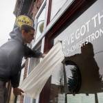Ethan Spain finishes putting a temporary vinyl on Freds Rivertown Ale House window with the phrase, weve got this #snohomishstrong on Friday in Snohomish. (Olivia Vanni / The Herald)