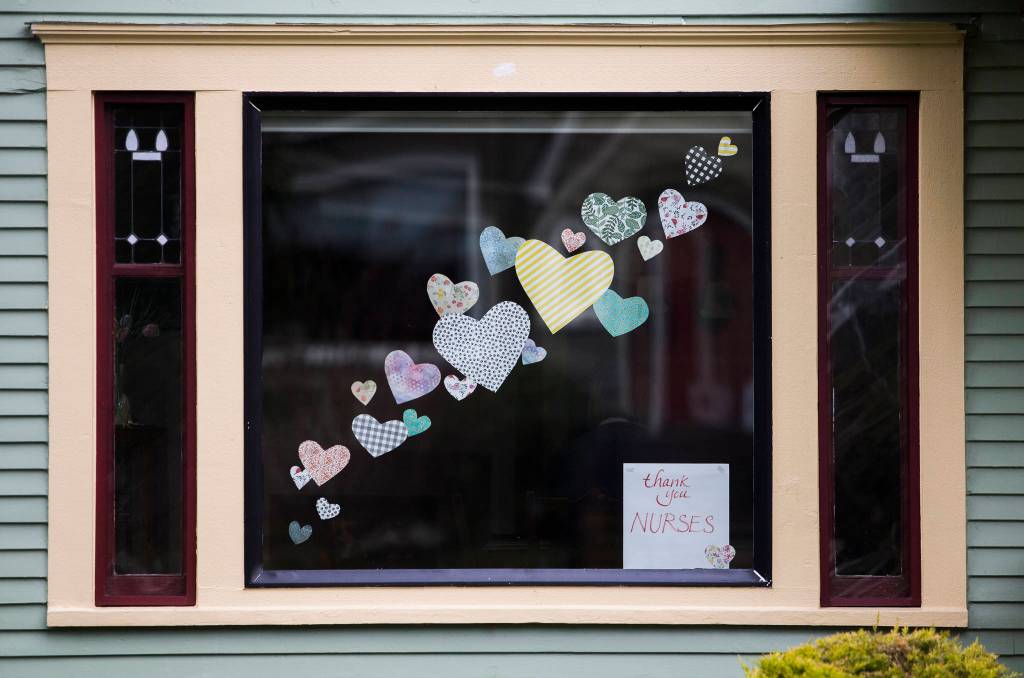 Paper hearts and a sign that says, thank you nurses are affixed to in a window of a home on Rucker Avenue in Everett. (Olivia Vanni / The Herald)