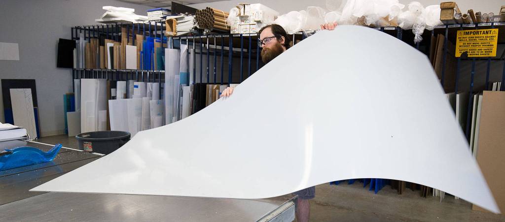 Store Manager Ben Winslow cuts sheets of plastic for customers orders at Tap Plastics on Monday in Everett. The cut sheets will be made into sneeze guards and face masks. (Andy Bronson / The Herald)