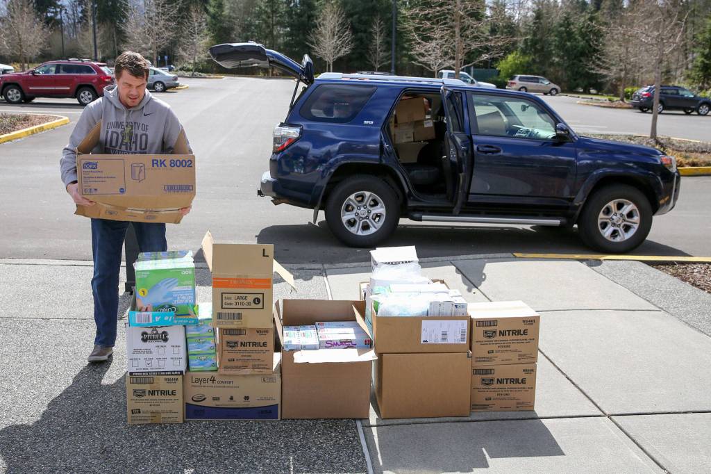 Keith Stefanson, Mukilteo School District facilities director, unloads personal protection equipment donated by the district on Wednesday at the Willis Tucker Park administration building in Snohomish. (Kevin Clark / The Herald)
