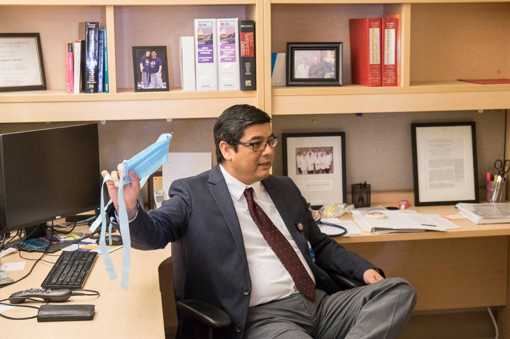 Providence Regional Medical Centers George Diaz M.D. holds up a mask made by a local company. Diaz saw the first patient with COVID-19 to be brought to the hospital. (Andy Bronson / The Herald)