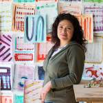 Everett artist Cat Snapp, with Covid-19 art, which she began working on before it became a pandemic, in her studio on Monday, April 13, 2020 in Everett, Wa. The wall art is mixed media on paper and the statues are abstracts made of Sculpy, a polymer clay. material. (Andy Bronson / The Herald)