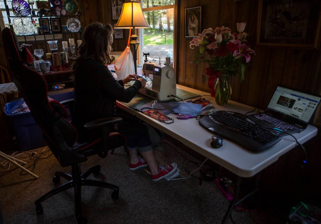 Nikki Speaks works at her new makeshift crafting table in her living room on April 10 in Woodinville. (Olivia Vanni / The Herald)