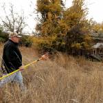 In this Oct. 28, 2019 photo, amateur botanist David Benscoter, of the Lost Apple Project, carries his apple picking pole as he walks while collecting apples in an orchard at a remote homestead near Pullman. (AP Photo/Ted S. Warren)