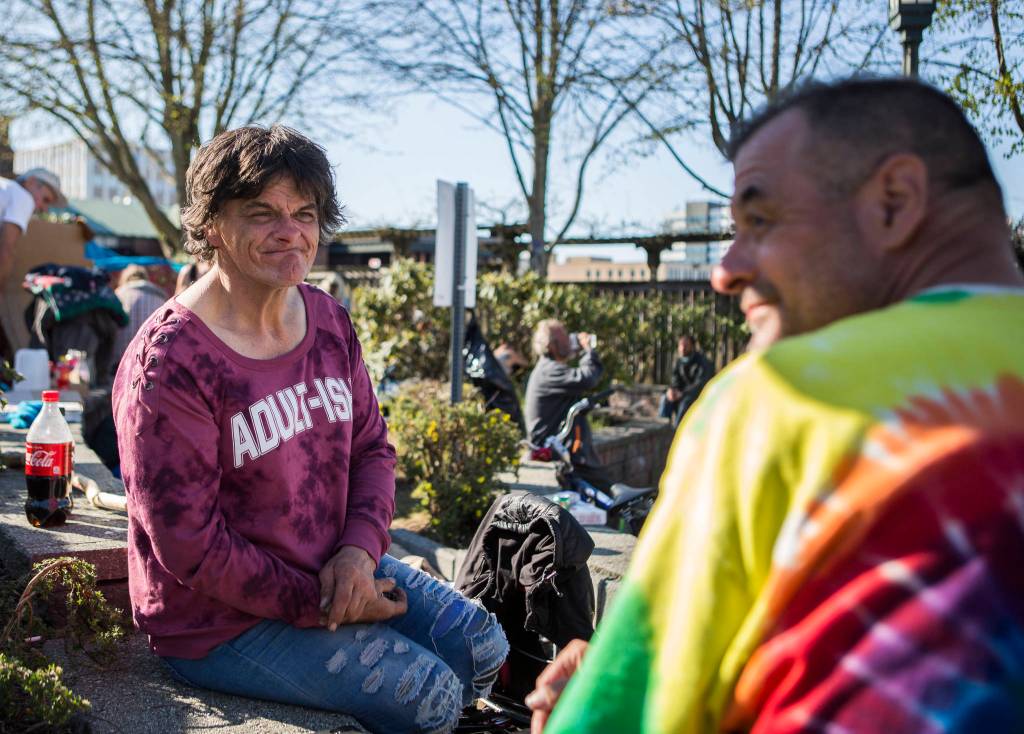 Teya (left) and Ted, both currently homeless, sit at Matthew Parsons Park at a homeless camp on Monday in Everett. Teya expressed frustration with a local shelter being full and an impending clearing of the park: If they actually cared about their homeless, they would give us more places to sleep. (Olivia Vanni / The Herald)