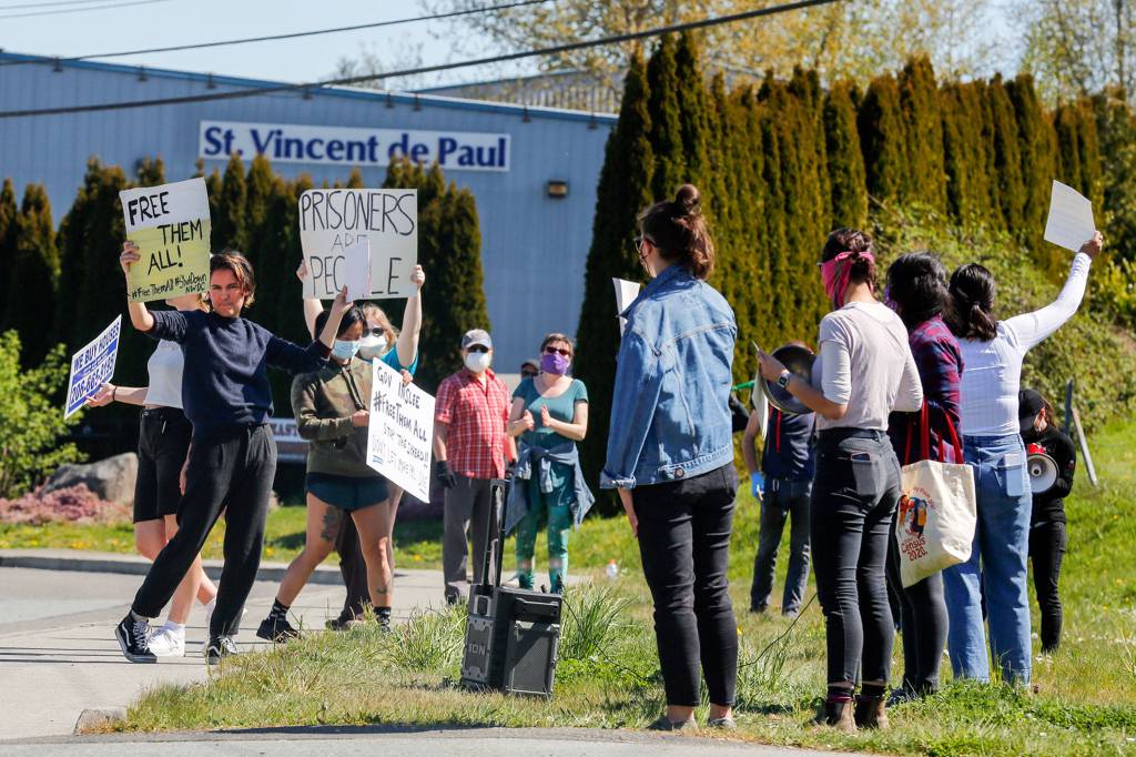 Protestors rally outside the grounds of the Monroe Correctional Complex in Monroe on Thursday. (Kevin Clark / The Herald)