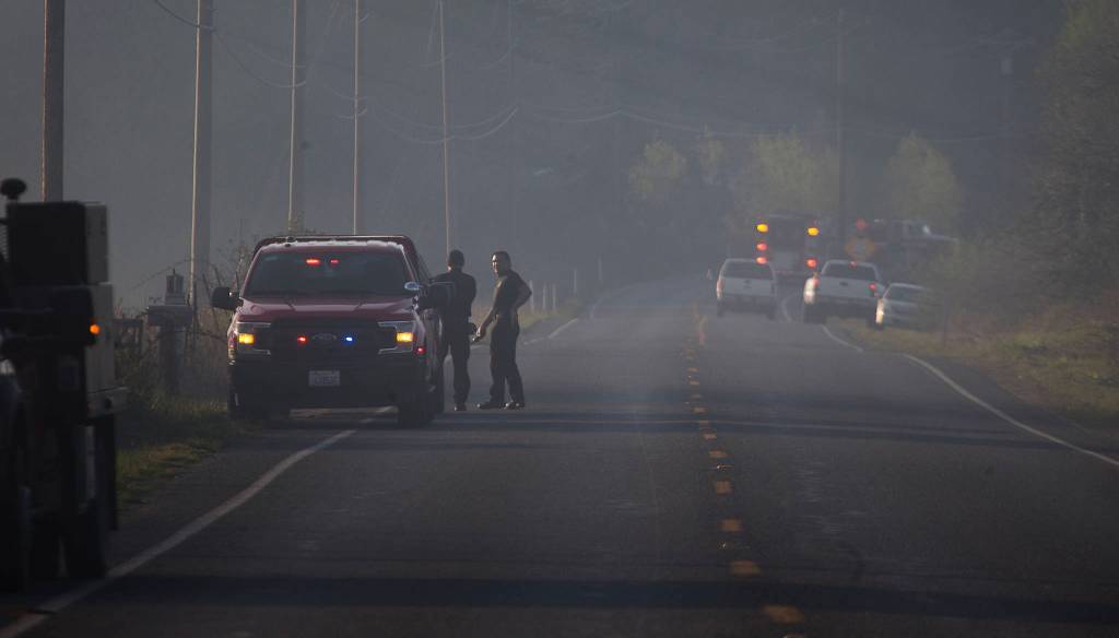 Smoke hovers over Highway 9 as multiple strike teams from Snohomish County fire departments fight a brush fire Wednesday in Bryant. (Andy Bronson / The Herald)