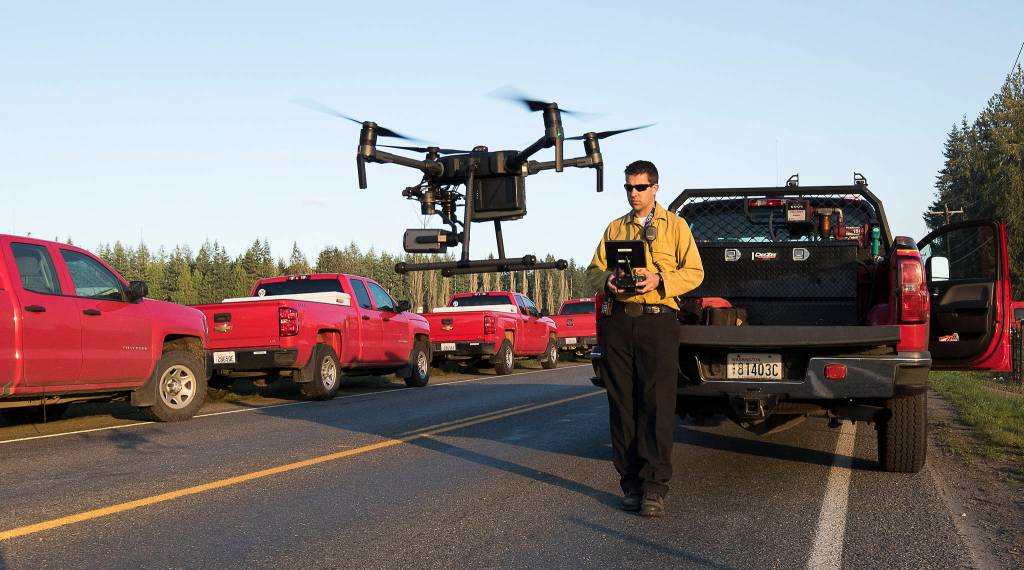 Getchell Fire Department Assistant Fire Chief Jeremy Stocker flies a drone to look for hot spots using a thermal camera at a brush fire along Highway 9 on Wednesday in Bryant. (Andy Bronson / The Herald)