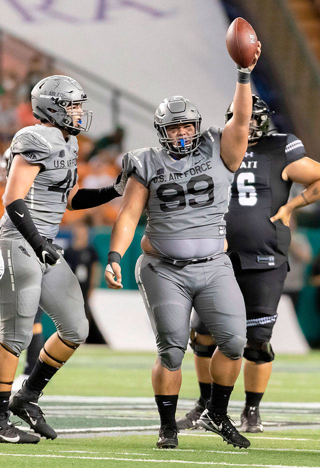 Air Force defensive lineman Mosese Fifita (99), a Glacier Peak alum, holds up the football to celebrate recovering a fumble during a game against Hawaii on Oct. 19, 2019, in Honolulu. (AP Photo/Eugene Tanner)